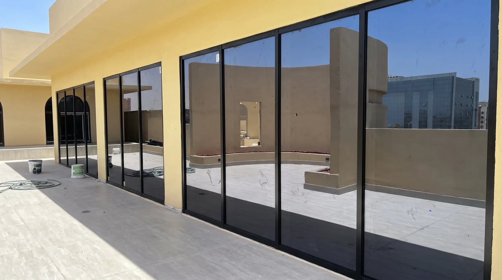 A terrace of the villa with black-framed sliding glass doors