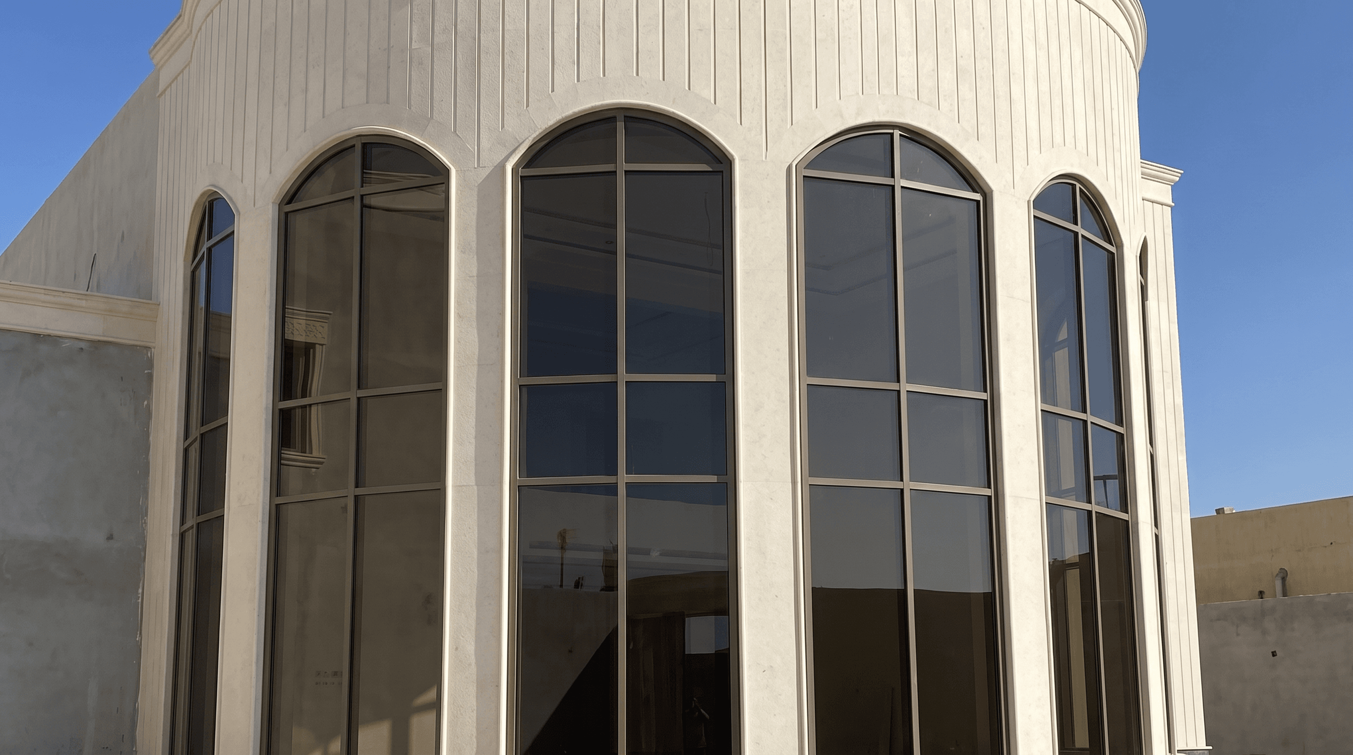 A stone villa in Al Malqa with arched aluminum-framed windows